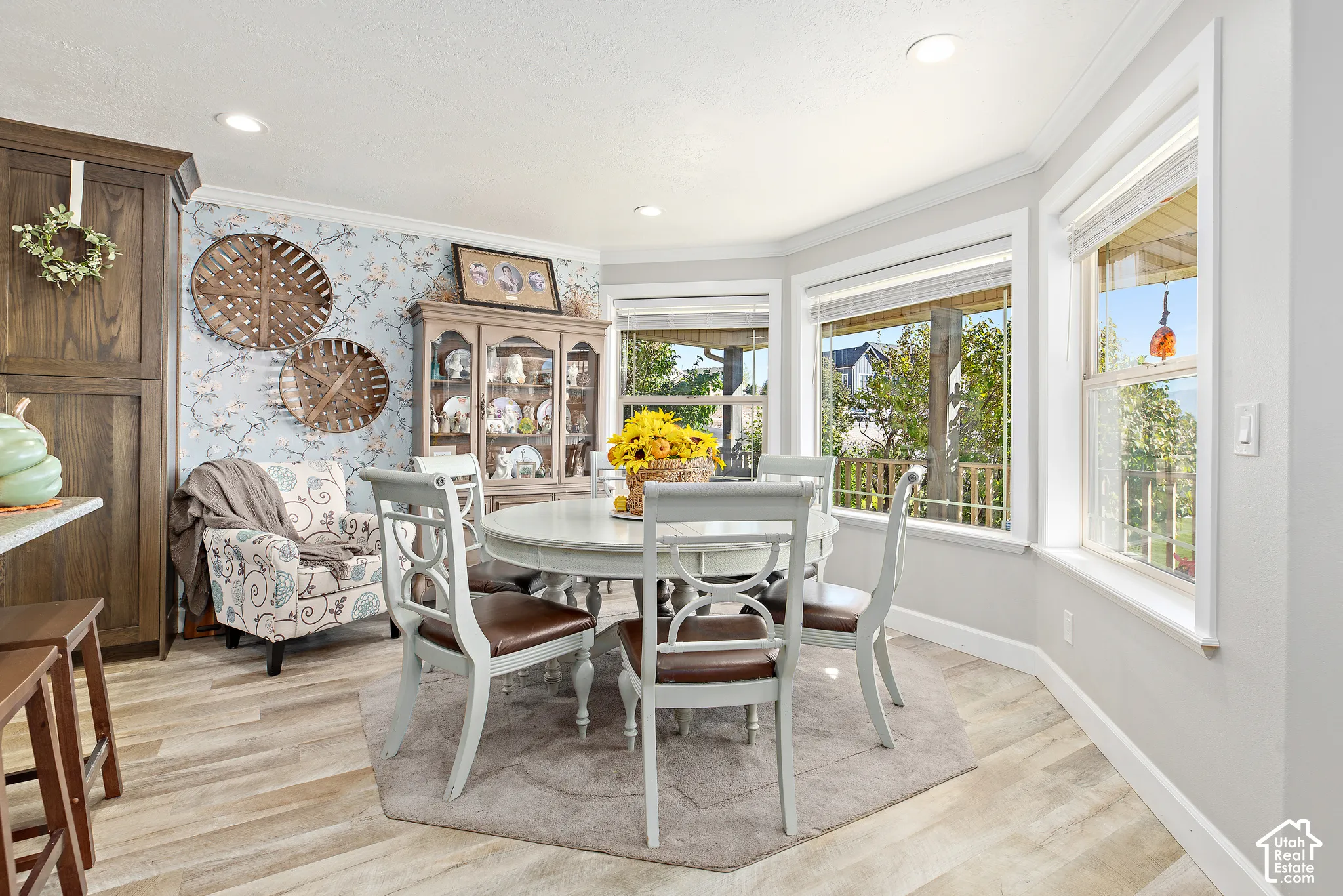 Bay window with multiple panes, crown molding, wood-finish flooring, built-in cabinetry, and recessed lighting
