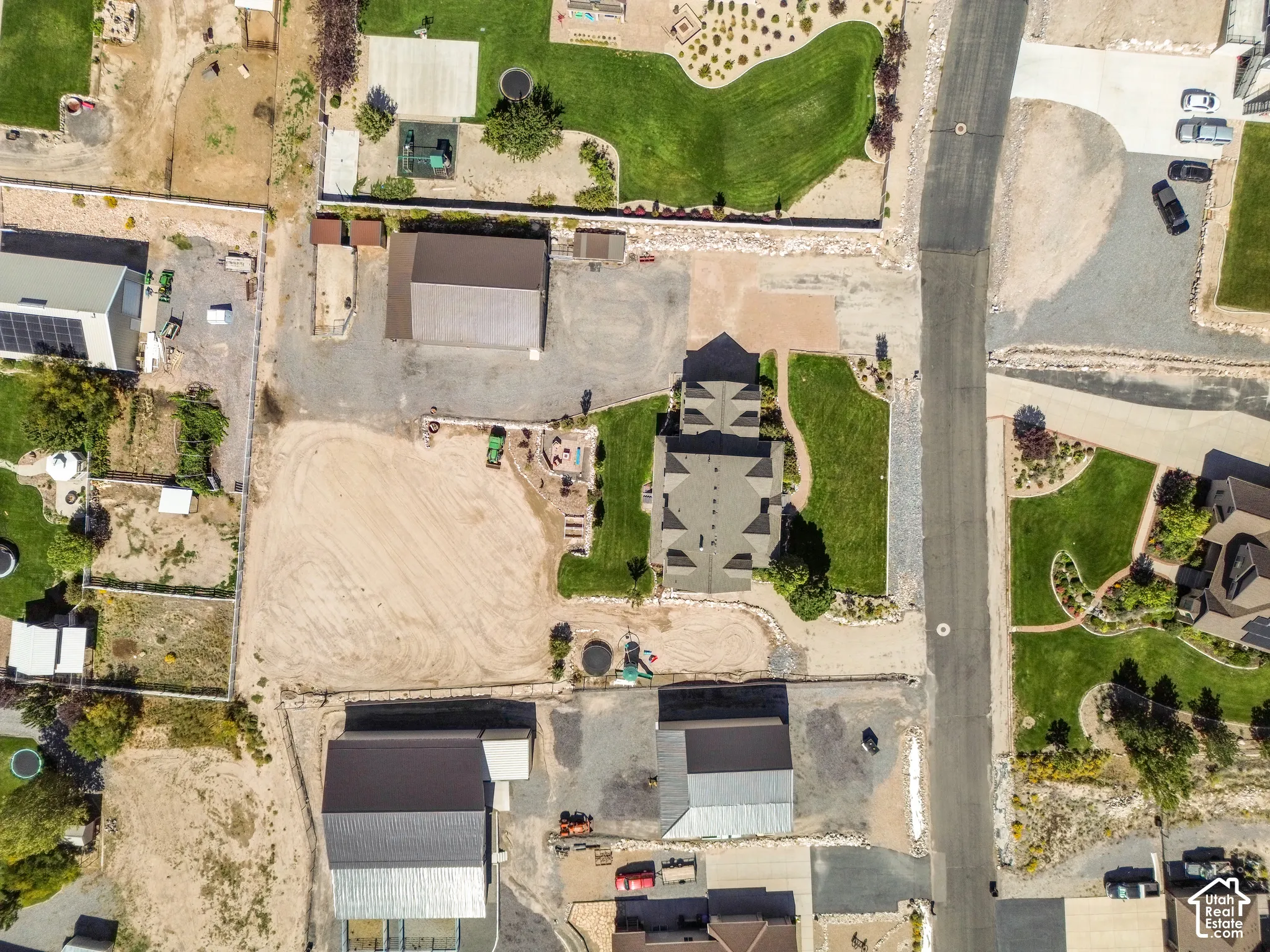 Property featuring a central residence, extensive manicured lawn areas, multiple outbuildings, and a substantial unpaved lot
