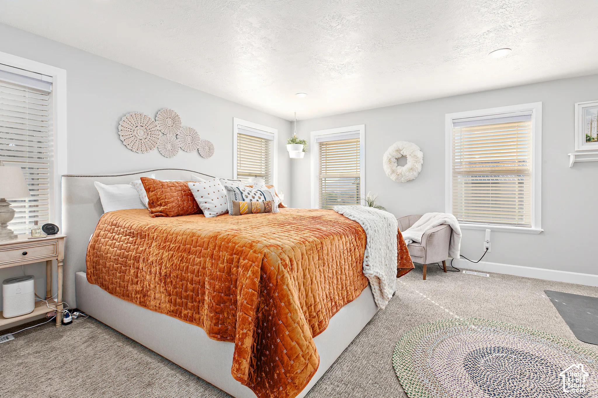 Carpeted bedroom with multiple windows, recessed lighting, and ample natural light