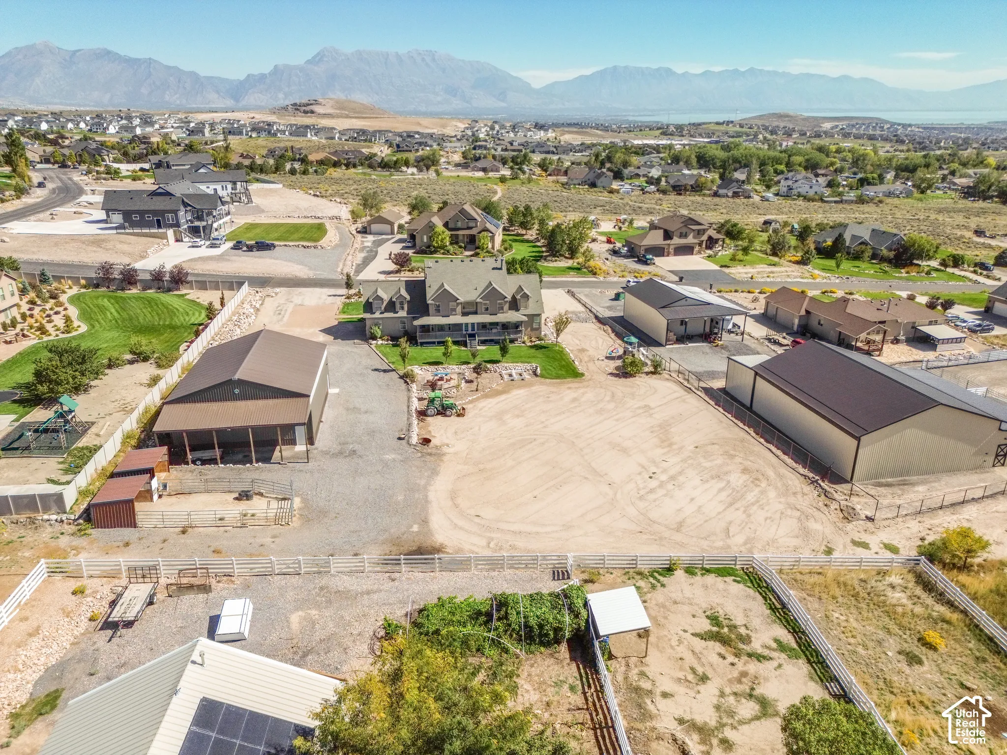 Expansive property featuring a spacious main residence, two large outbuildings, a separate shed, and a fenced perimeter