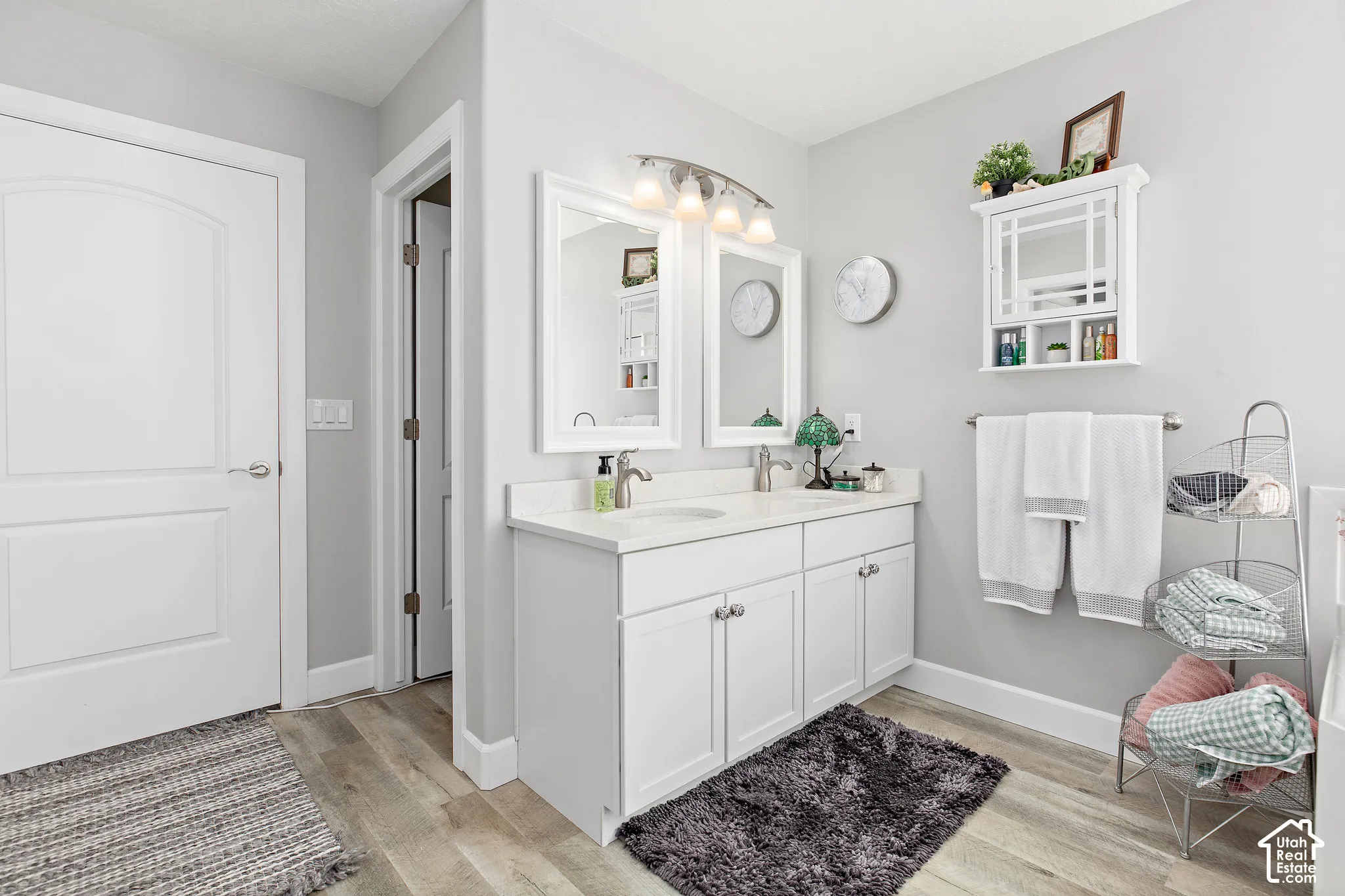 Dual vanity with white cabinetry, light-toned countertops, and two framed mirrors
