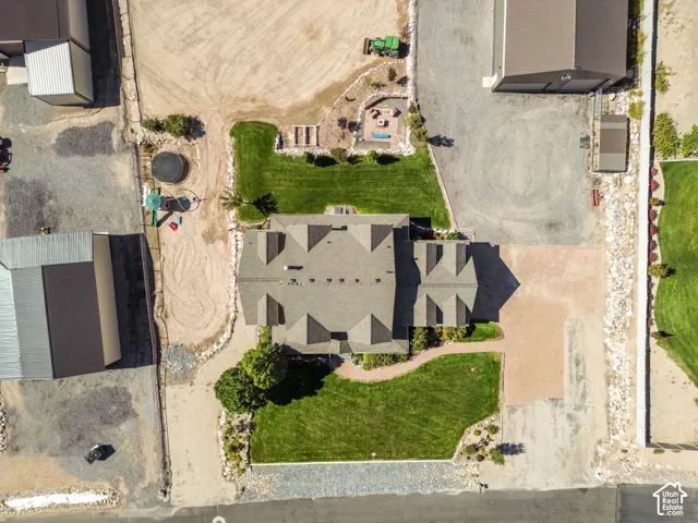 Expansive lot featuring a large main residence with a multi-gabled roof, multiple outbuildings, and extensive gravel and paved hardscaping