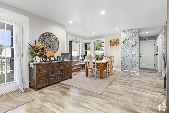 Wood-finish flooring throughout, recessed lighting, bay windows with multiple panes, and a door with a full-light panel