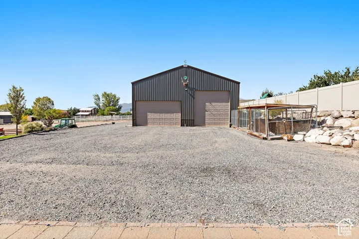 Metal utility building with two roll-up doors and gravel surfacing