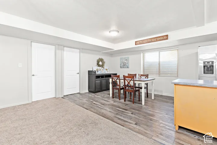 Wood-finish flooring, recessed lighting, and a stainless steel refrigerator