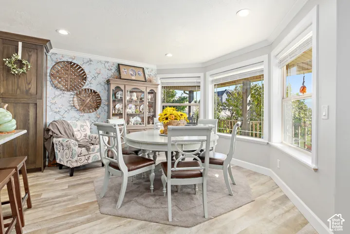 Bay window with multiple panes, crown molding, wood-finish flooring, built-in cabinetry, and recessed lighting