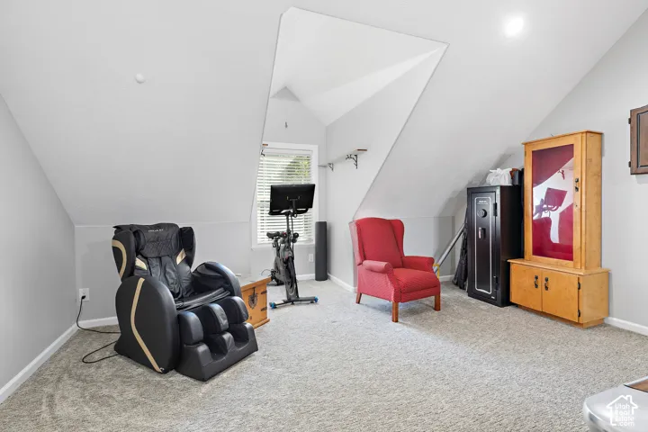 Carpeted room with sloped ceilings, recessed lighting, and a window with blinds