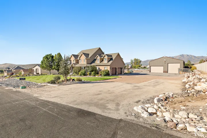 Two-story residence with a three-car garage, an additional detached two-car garage, and a expansive gravel lot