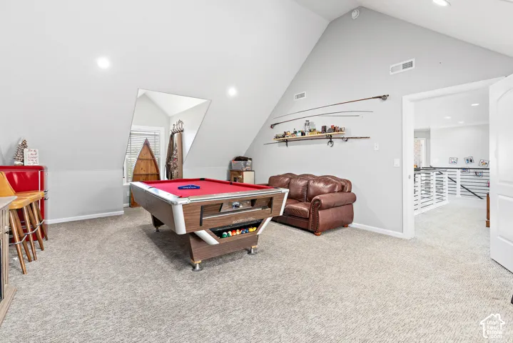 Spacious bonus room featuring sloped ceilings, recessed lighting, and soft carpeting
