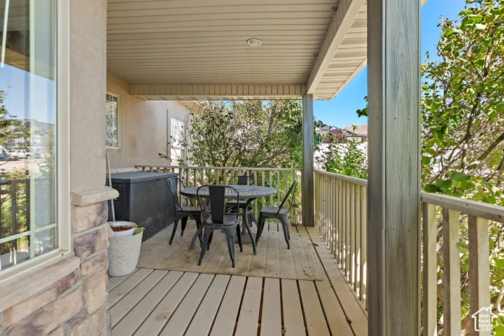 Covered exterior deck with wood-finish flooring, stone fa