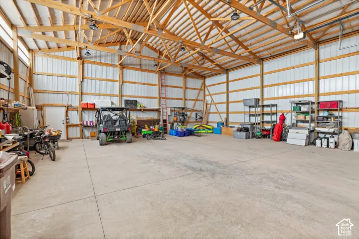 Spacious interior featuring exposed wood trusses, concrete flooring, and corrugated metal walls