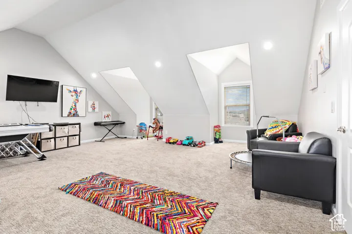 Spacious bonus room featuring sloped ceilings, recessed lighting, and a window with blinds