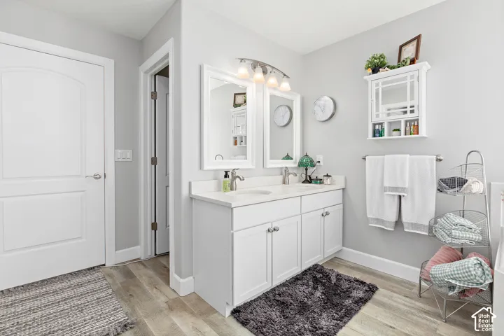 Dual vanity with white cabinetry, light-toned countertops, and two framed mirrors