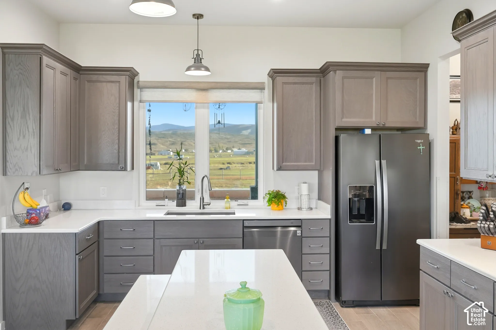 Kitchen featuring gray cabinetry, white countertops, stainless steel appliances, and a central island