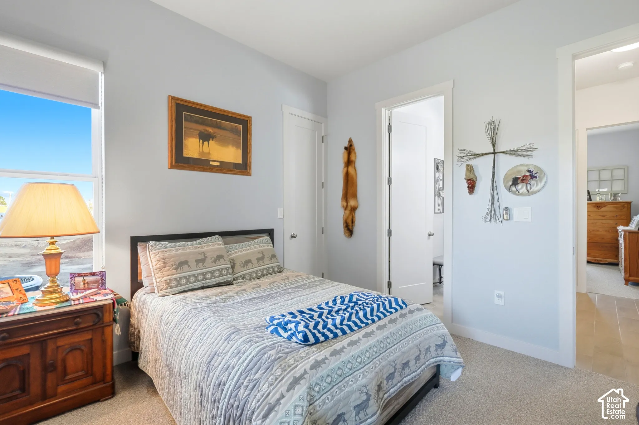 Carpeted bedroom featuring a large window, a solid-core door, and light-toned wall paint