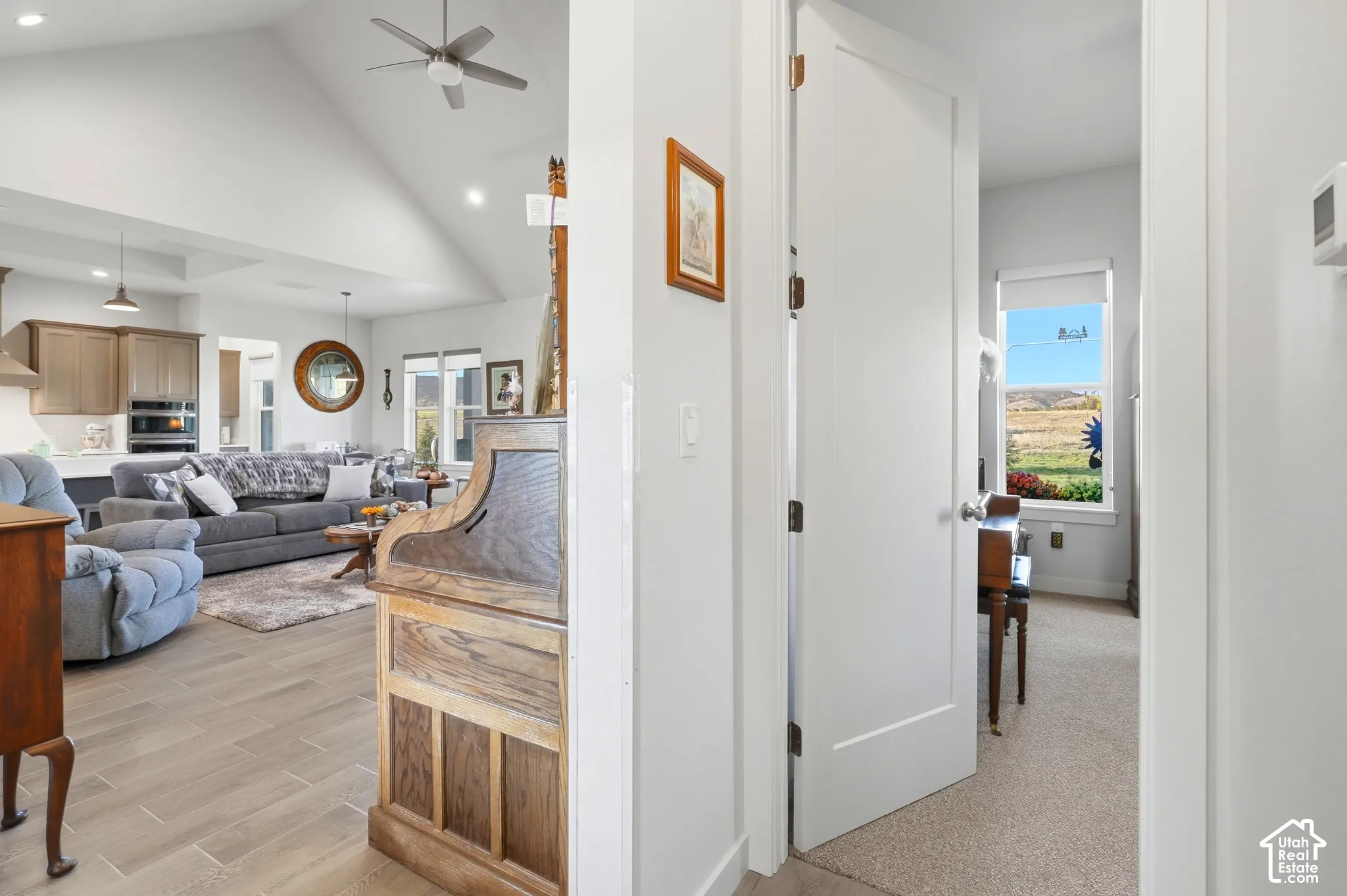 Vaulted ceilings, recessed lighting, and wood-finish flooring define this bright living area