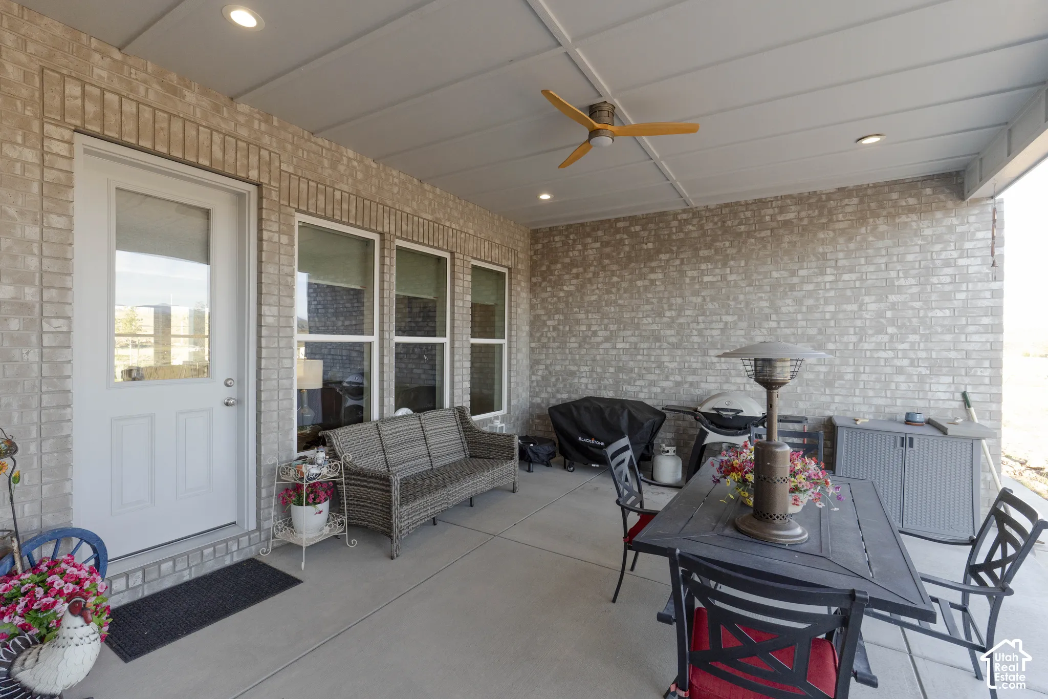 Covered patio featuring a ceiling fan, recessed lighting, and a brick exterior