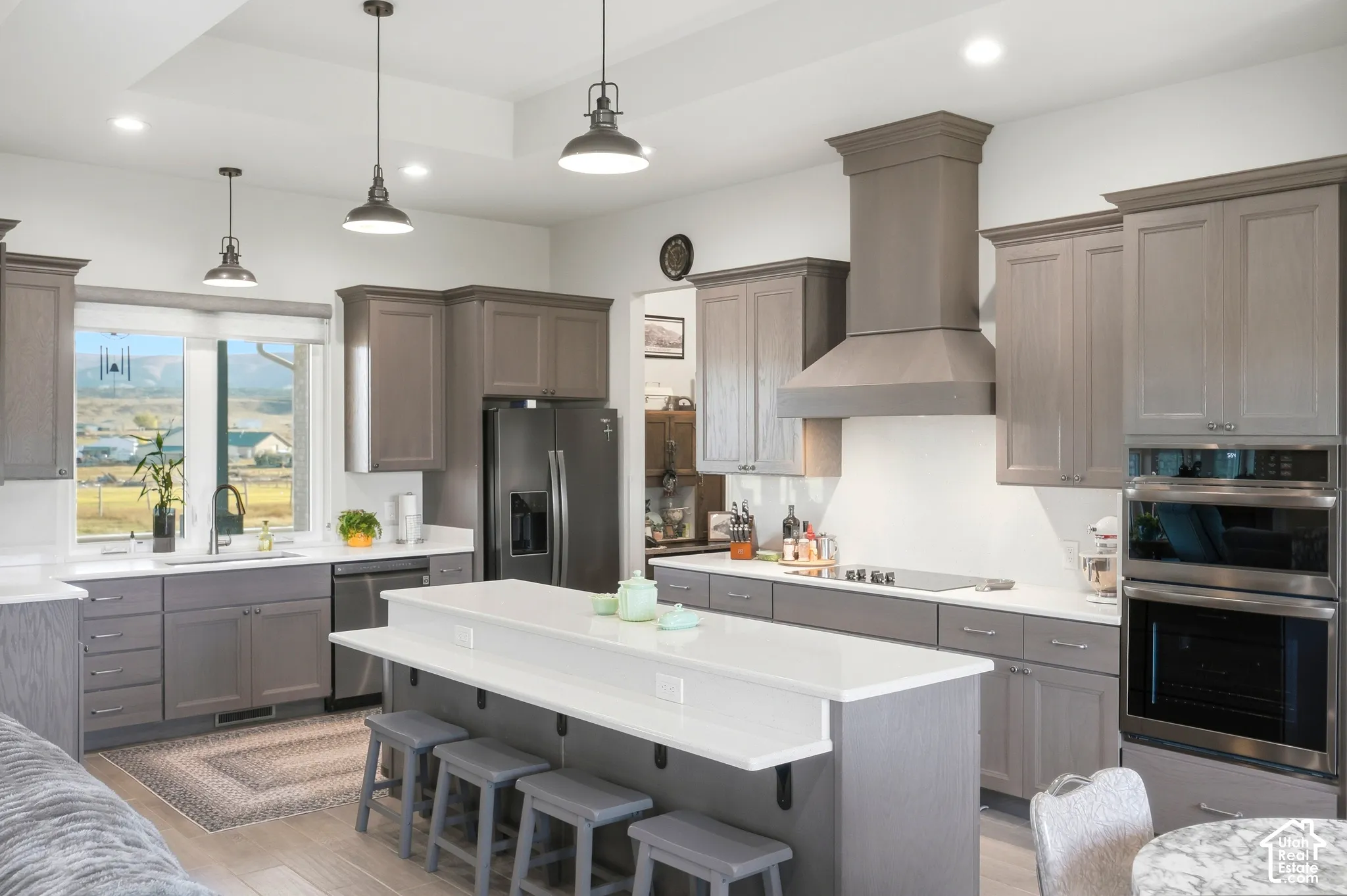 Kitchen featuring gray cabinetry, white countertops, a center island with bar seating, stainless steel appliances, and recessed lighting