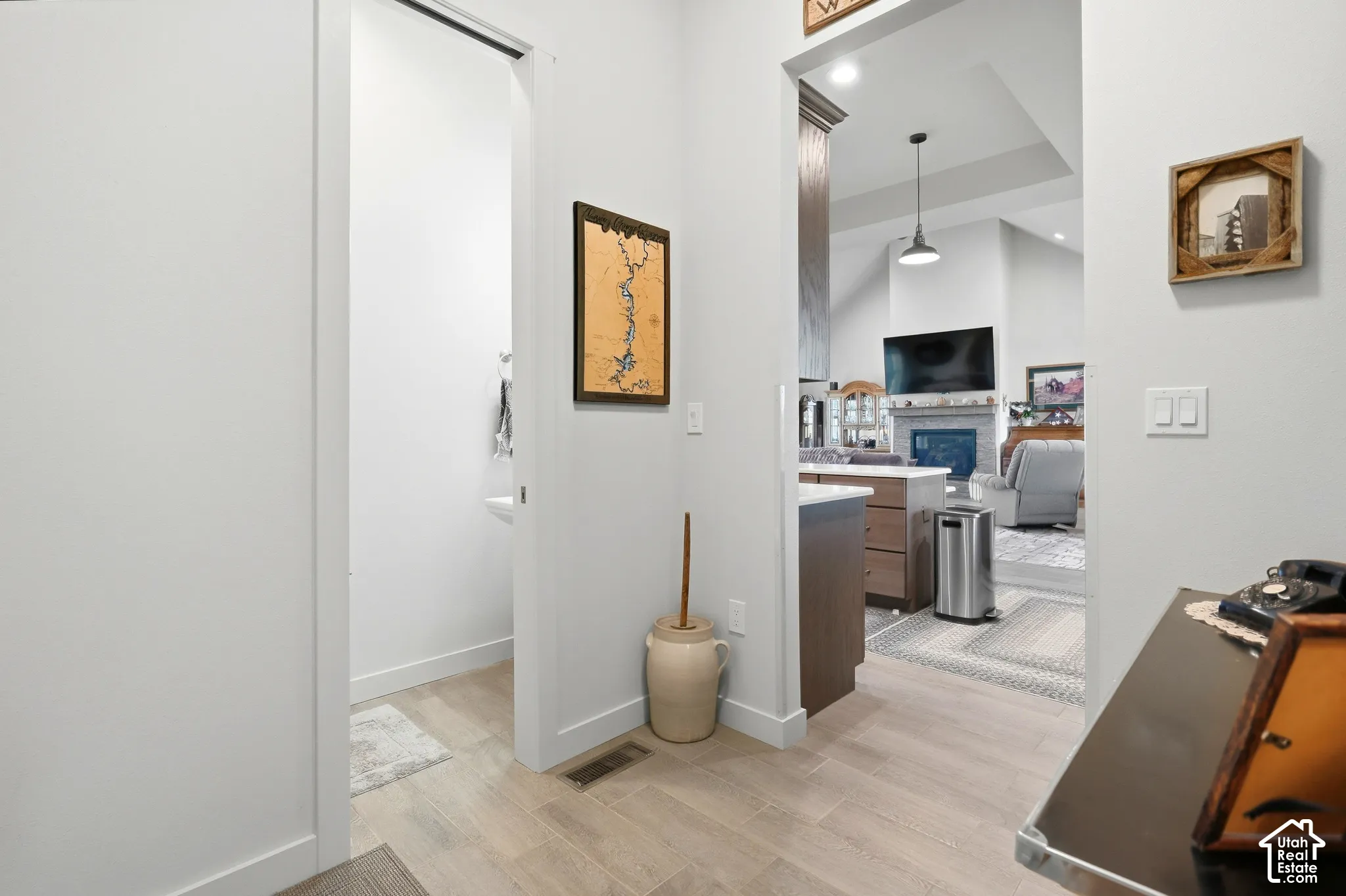 Wood-finish flooring throughout, bright white wall finishes, and an open entryway to the main living area