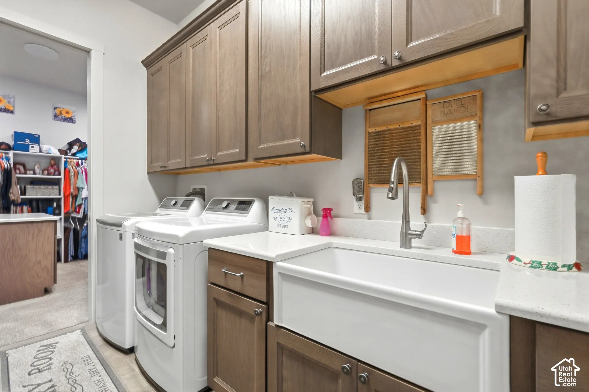 Laundry area featuring a built-in sink, upper cabinetry, lower cabinetry, and a countertop
