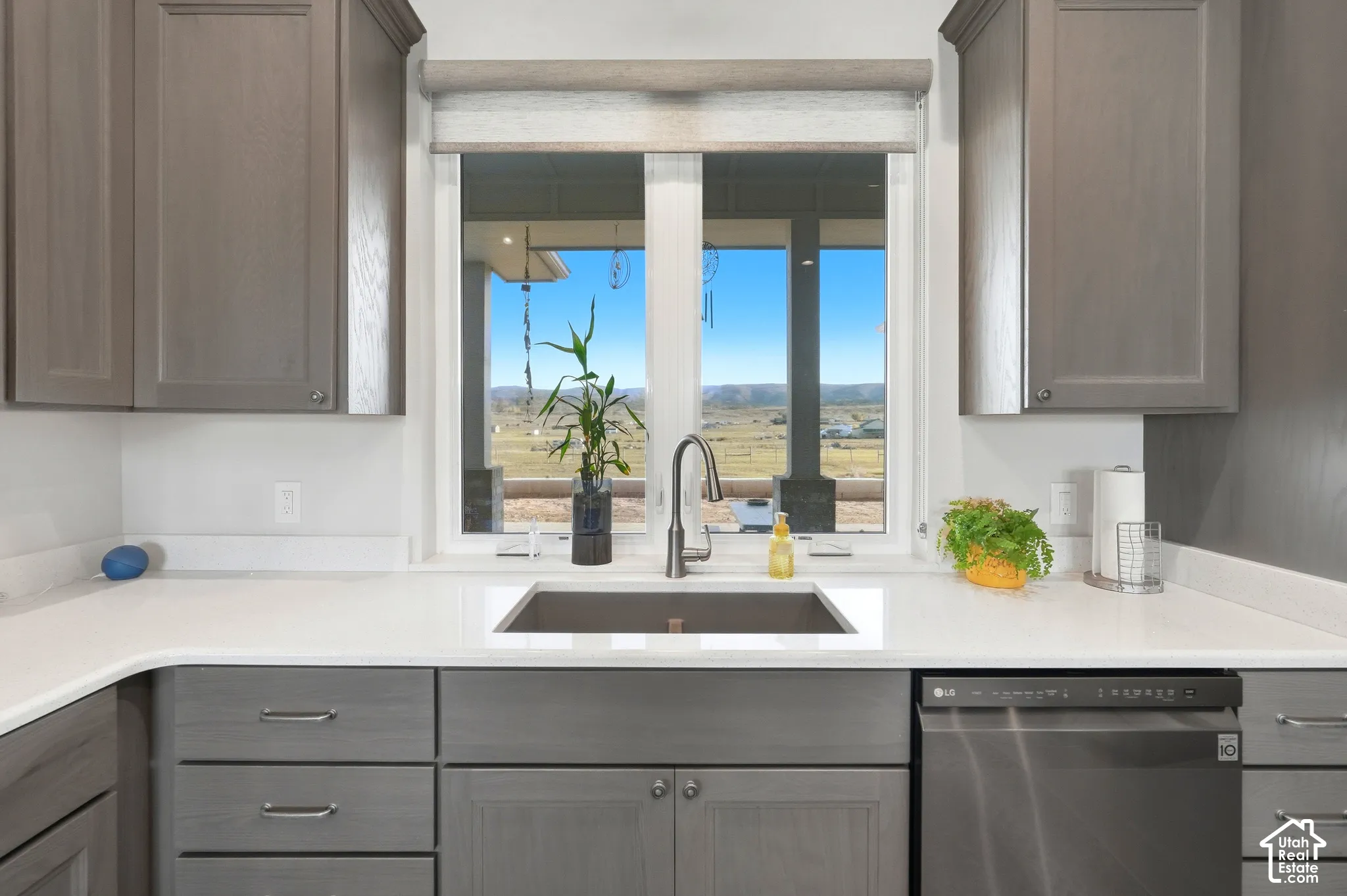 White solid surface countertops with a matte black faucet and undermount sink