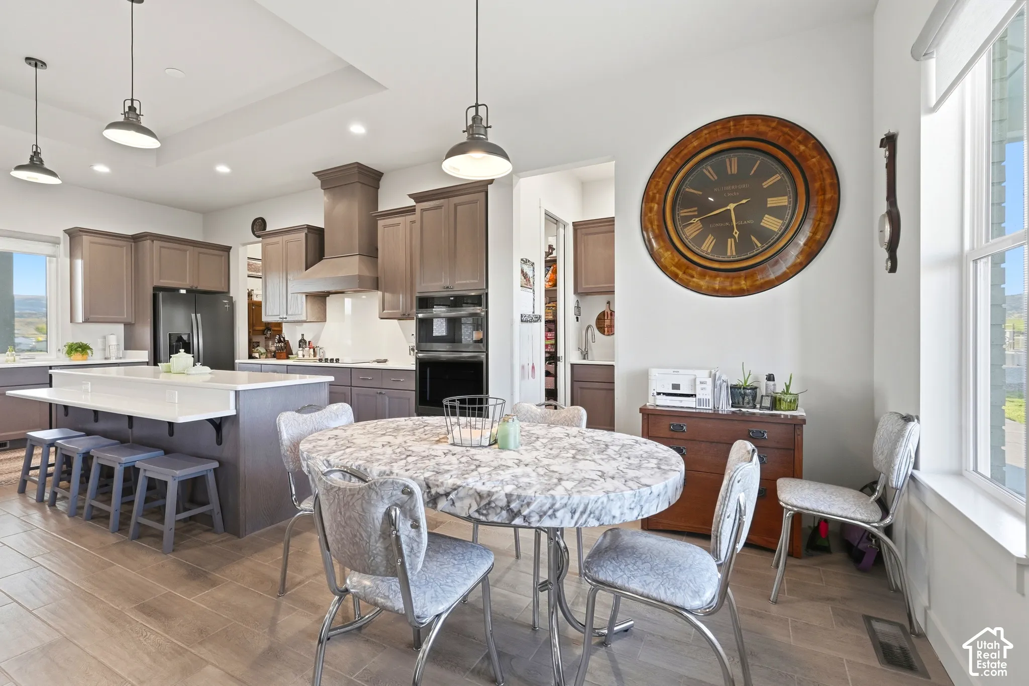 Gourmet kitchen featuring a large central island with seating, stainless steel appliances, and wood-finish flooring