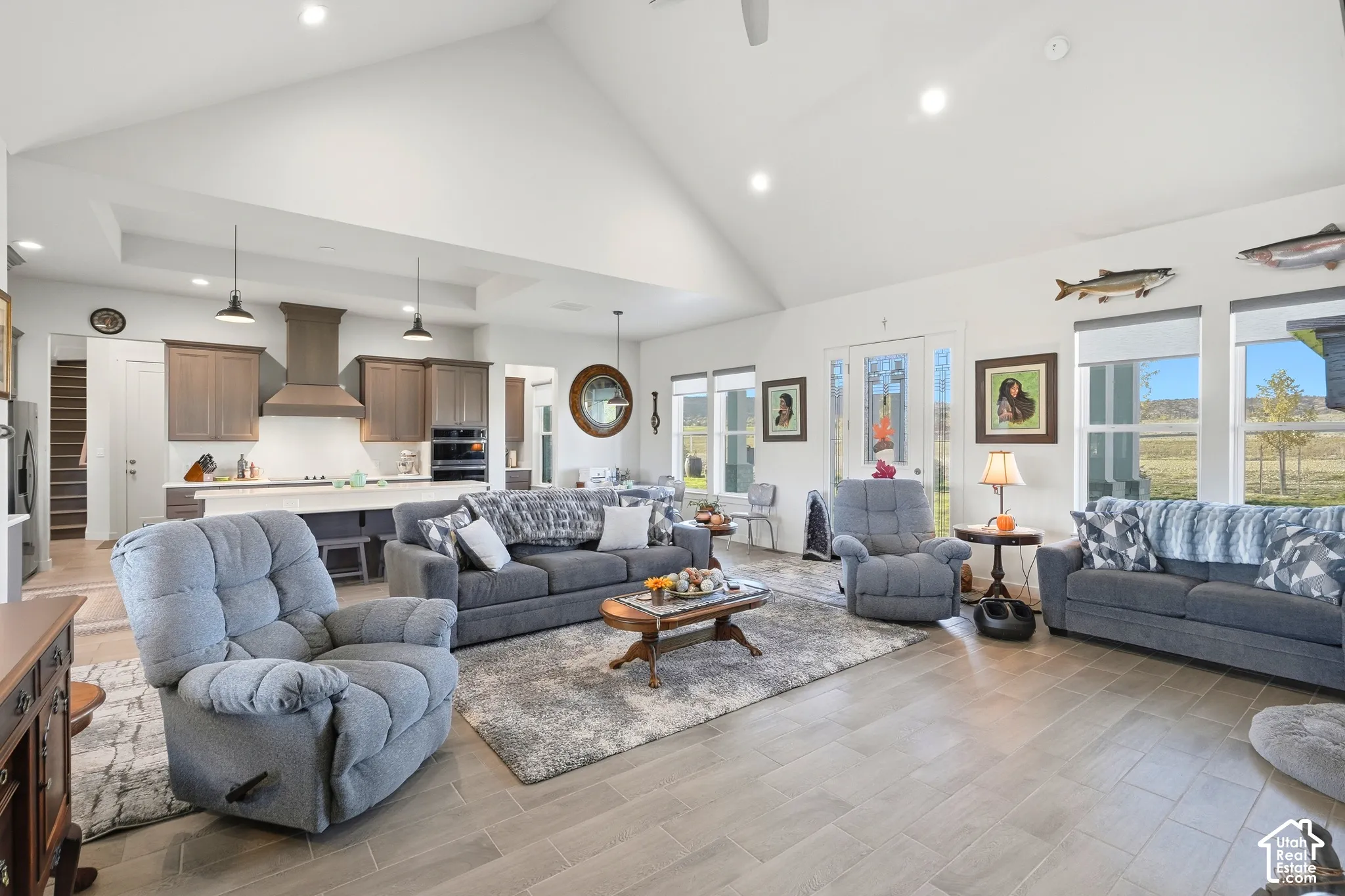 Vaulted ceiling, recessed lighting, wood-finish flooring, kitchen island, and multiple windows
