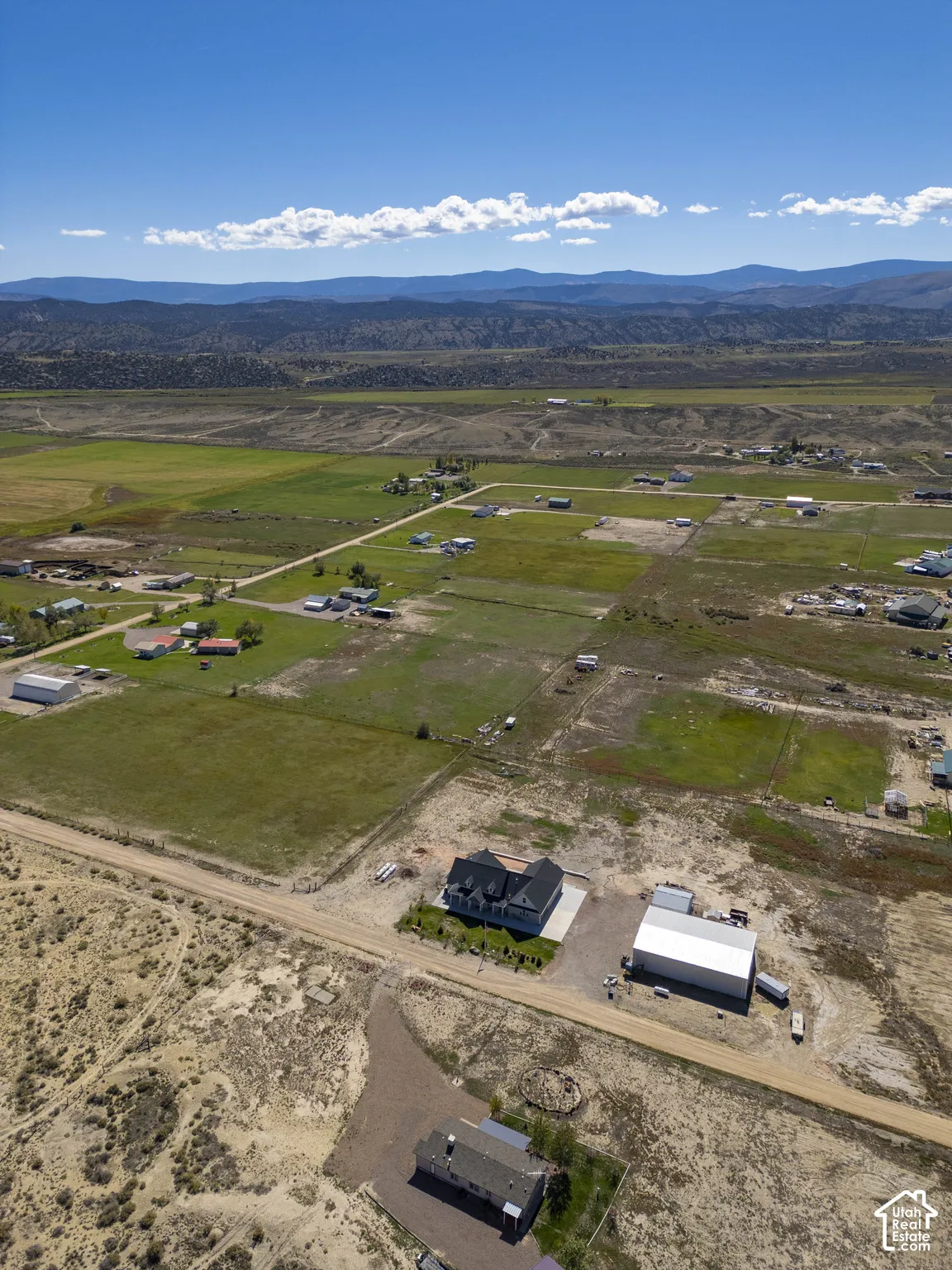 Property featuring expansive surrounding land, a detached outbuilding, and distant mountain scenery