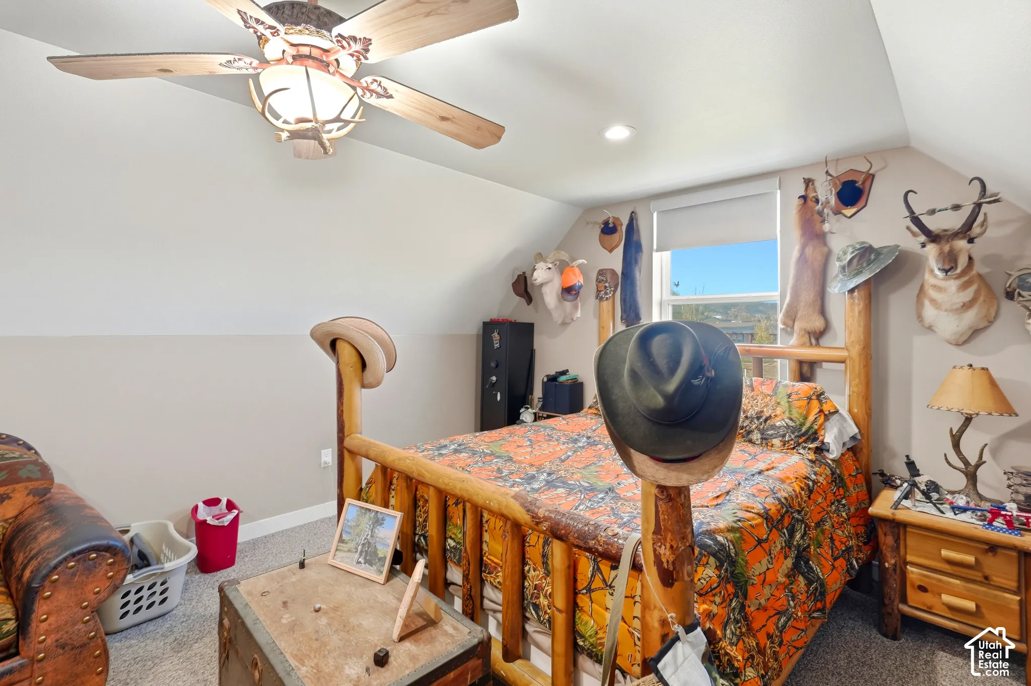 Sloped ceilings with recessed lighting, wood-finish ceiling fan, window with roller shade, and wood-frame bed