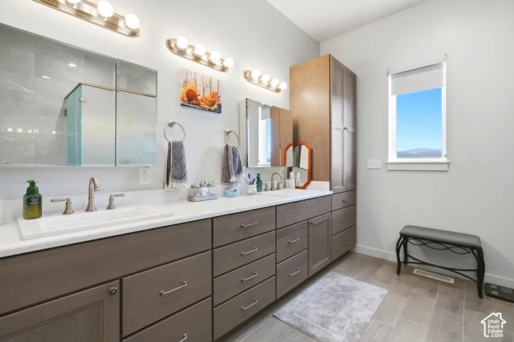 Dual vanity with integrated sinks, brushed nickel fixtures, and extensive under-counter storage cabinetry
