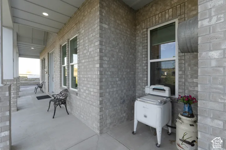 Porch with light-colored brick exterior, white window frames, and recessed lighting