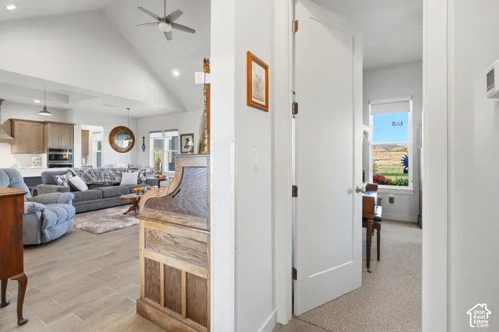 Vaulted ceilings, recessed lighting, and wood-finish flooring define this bright living area