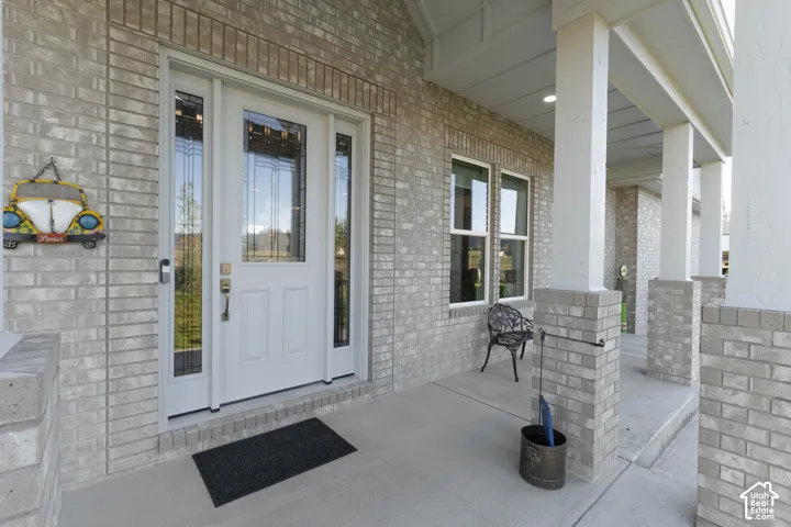 Brick exterior with covered front porch, white columns, and transom window entryway