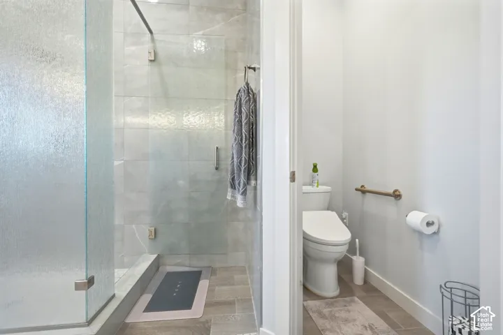 Walk-in shower with clear and textured glass enclosures, light-toned wall tile, and coordinating floor tile