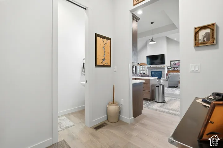 Wood-finish flooring throughout, bright white wall finishes, and an open entryway to the main living area