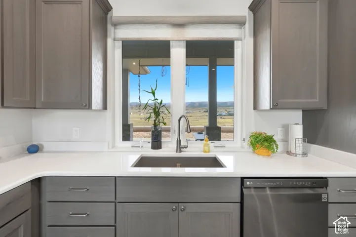 White solid surface countertops with a matte black faucet and undermount sink