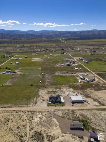 Expansive property featuring a residence, detached auxiliary building, and unpaved access roads