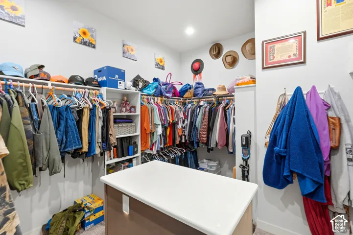 Built-in closet organization system with ample hanging rods, shelving, and a central island with a white countertop