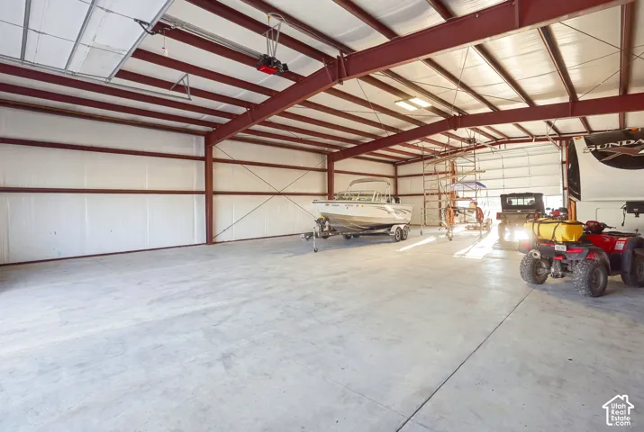 Spacious metal building featuring a concrete floor, exposed structural beams, and overhead lighting