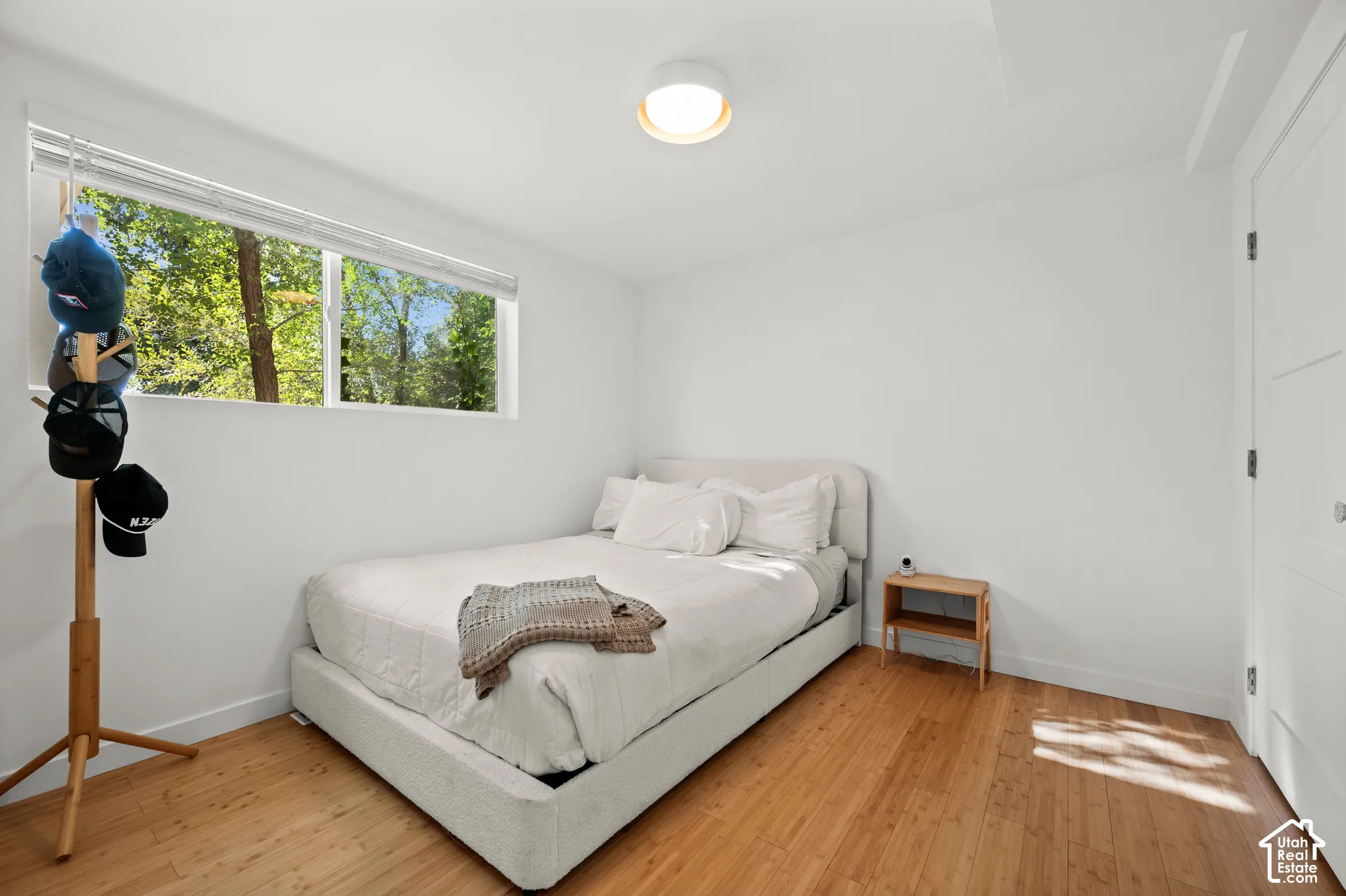 Natural wood flooring, white walls, and a contemporary flush-mount ceiling light