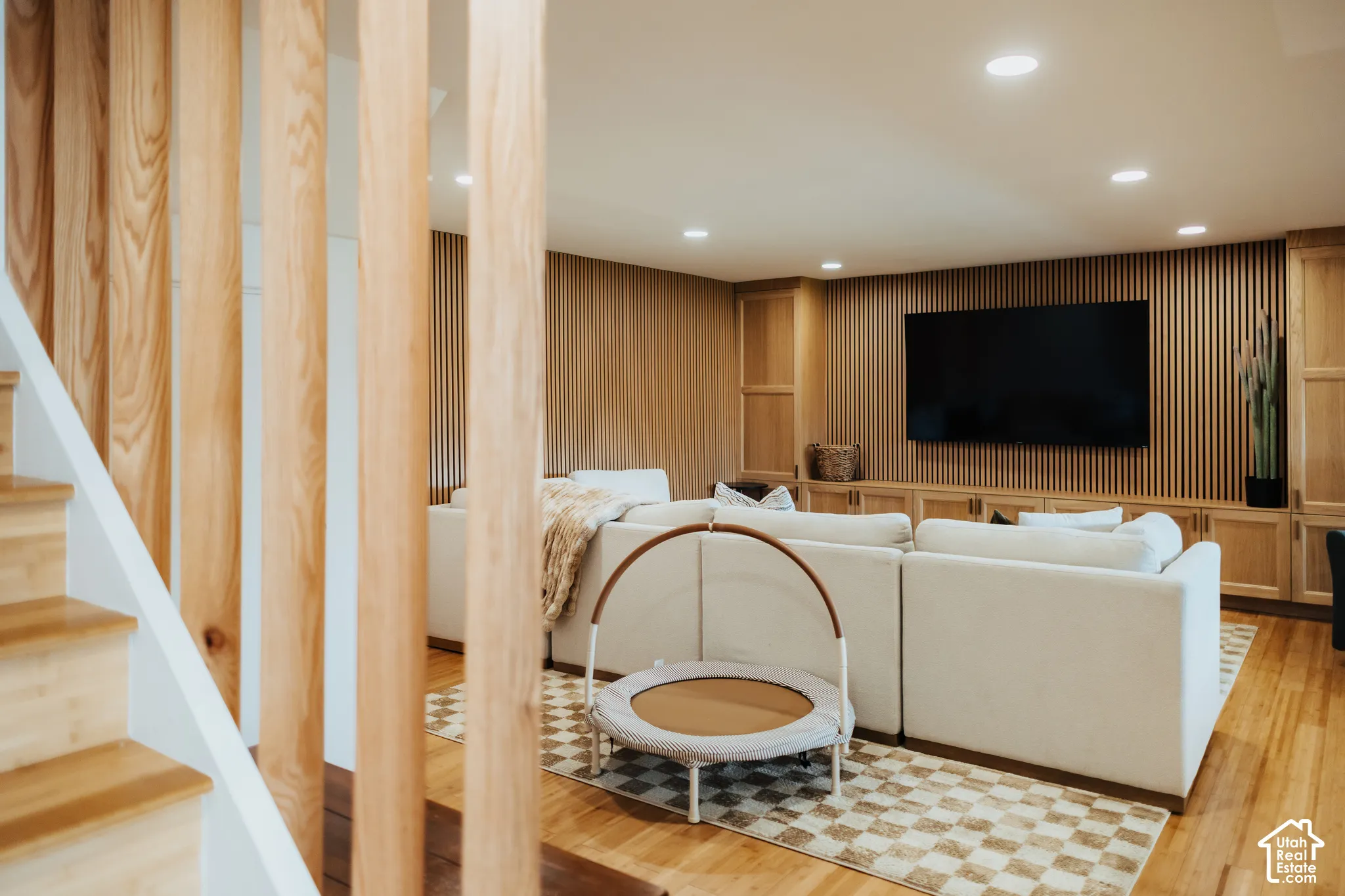 Wood-slat wall paneling, built-in cabinetry, recessed lighting, and wood-finish flooring