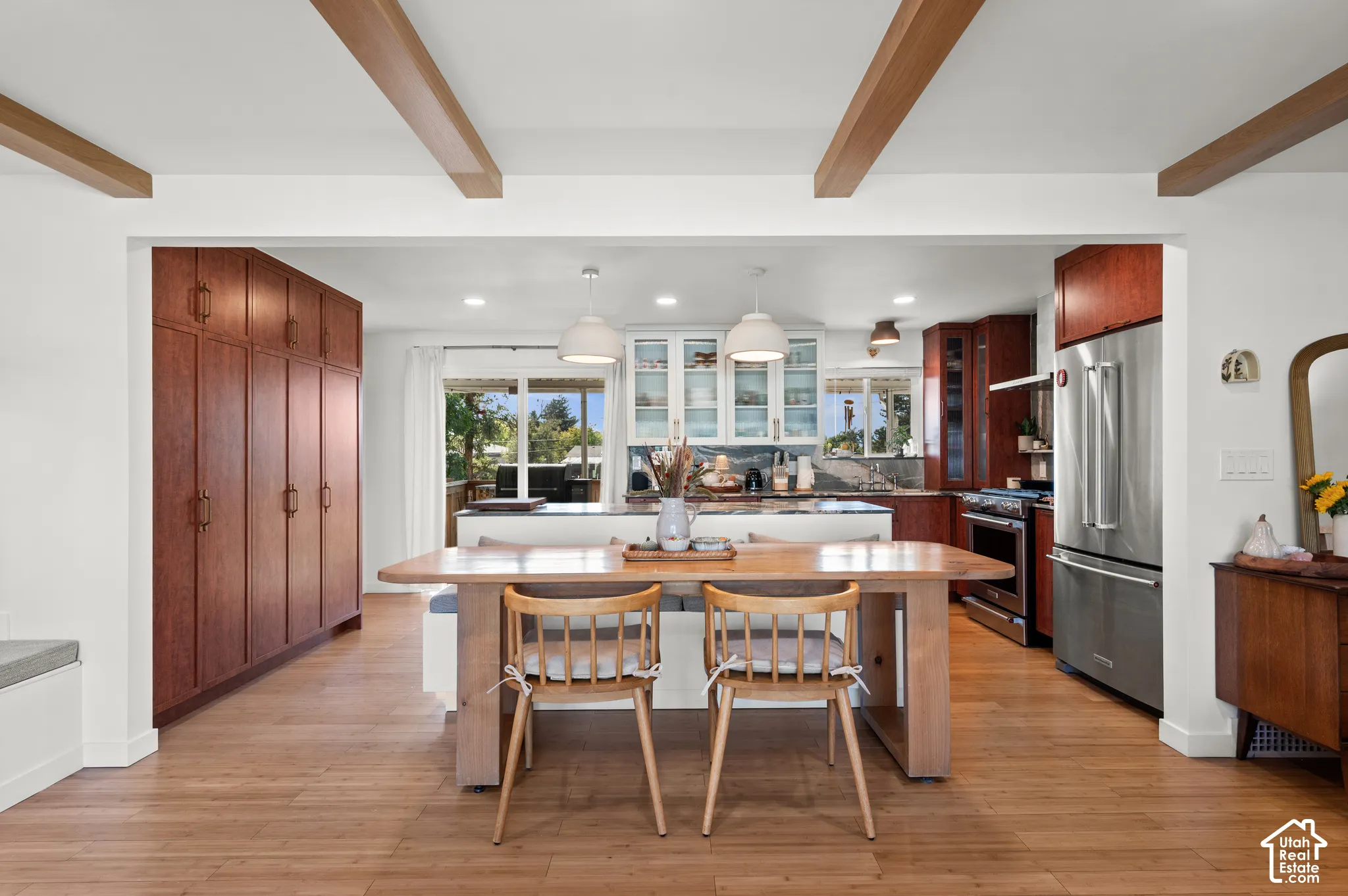 Open-concept living space featuring wood-finish flooring, exposed ceiling beams, and recessed lighting