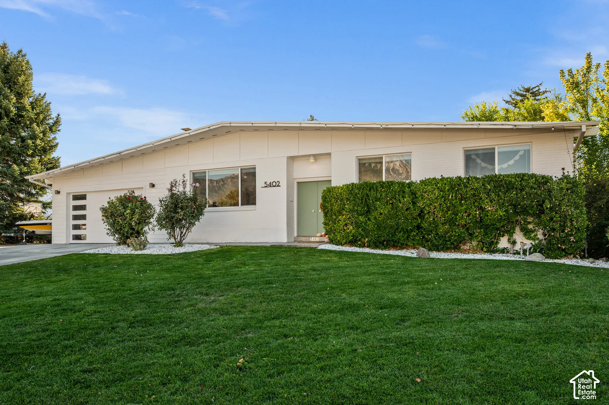 White exterior with contrasting front door and modern garage door