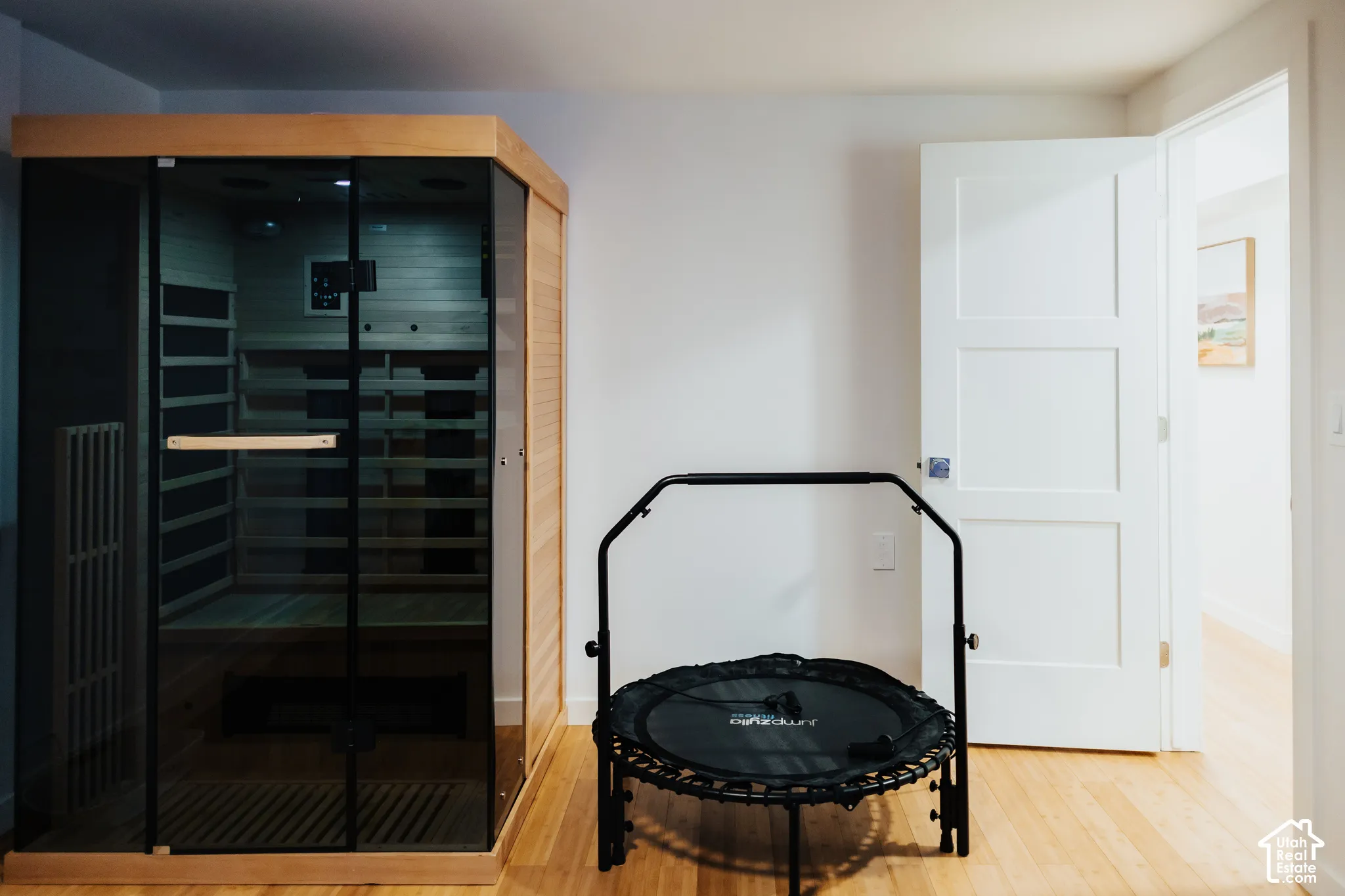 Built-in sauna featuring cedar interior cladding, glass door panels, and wood-finish flooring