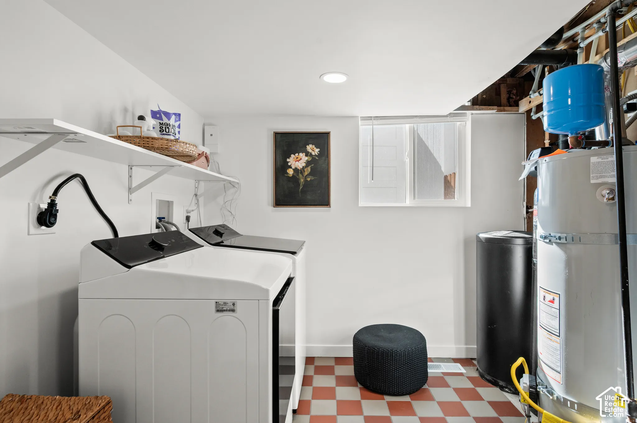 Laundry area featuring a window, built-in shelving, white walls, and checkerboard floor tiles