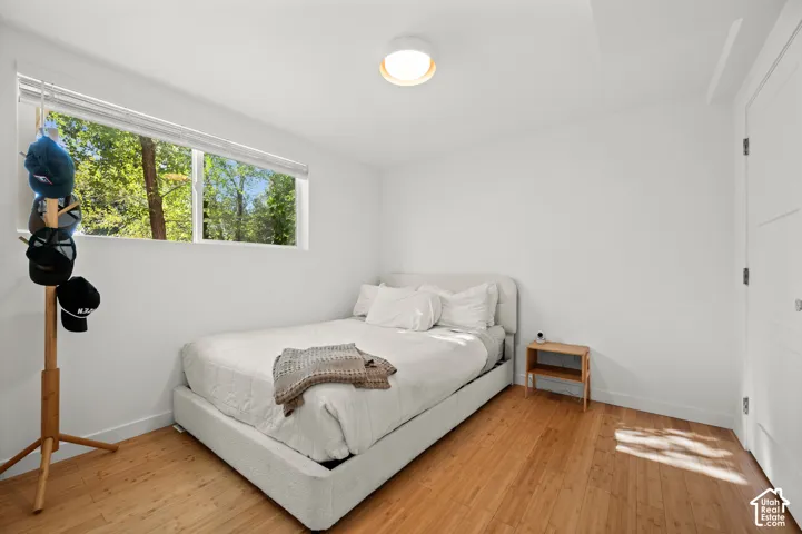 Natural wood flooring, white walls, and a contemporary flush-mount ceiling light