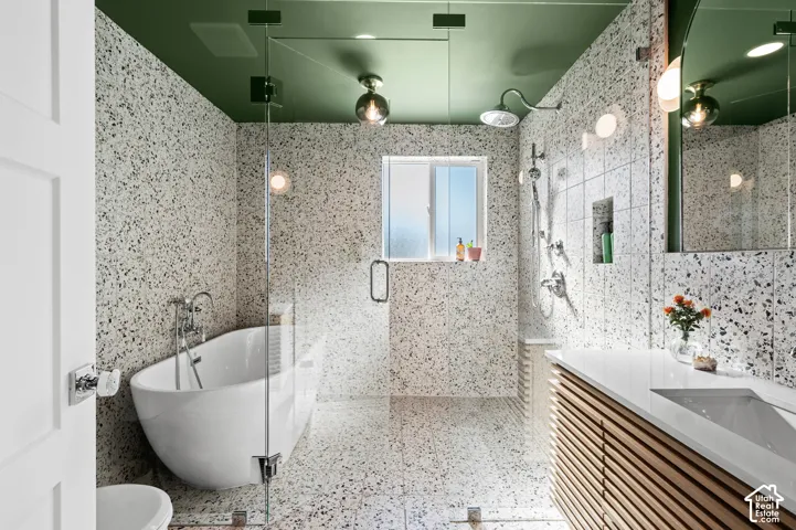 Bathroom featuring a freestanding soaking tub, glass-enclosed shower, wood-slat vanity with integrated sink, and an accent ceiling