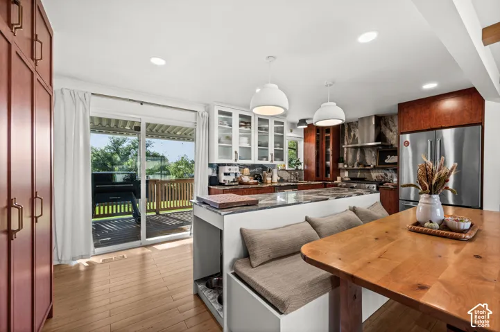 Open-concept kitchen with wood-finish flooring, built-in banquette seating, and a large central island