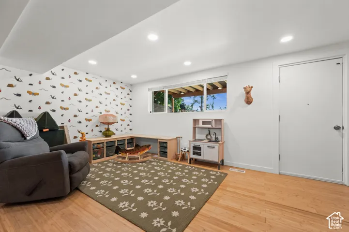 Light wood-finish flooring with a white door and trim