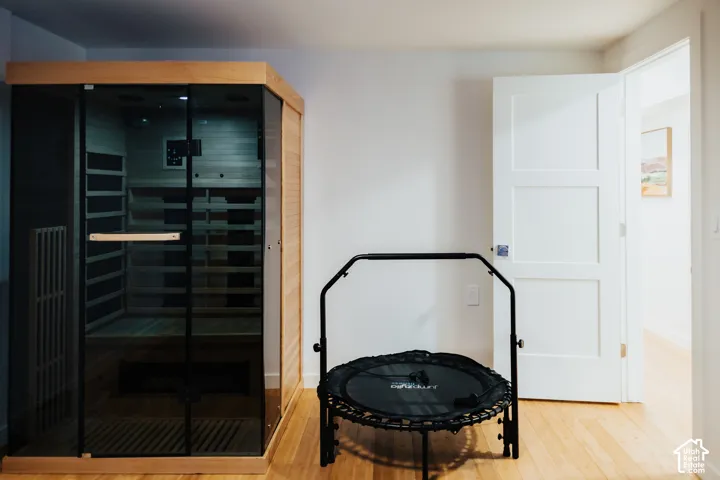 Built-in sauna featuring cedar interior cladding, glass door panels, and wood-finish flooring